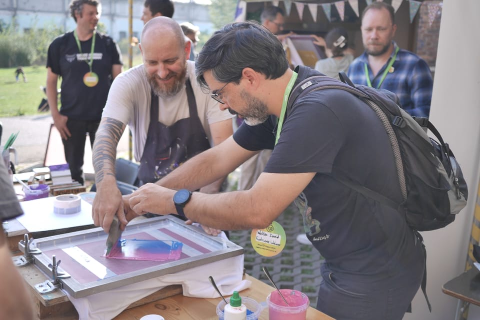 Two men screenprinting at the Heart of Clojure conference